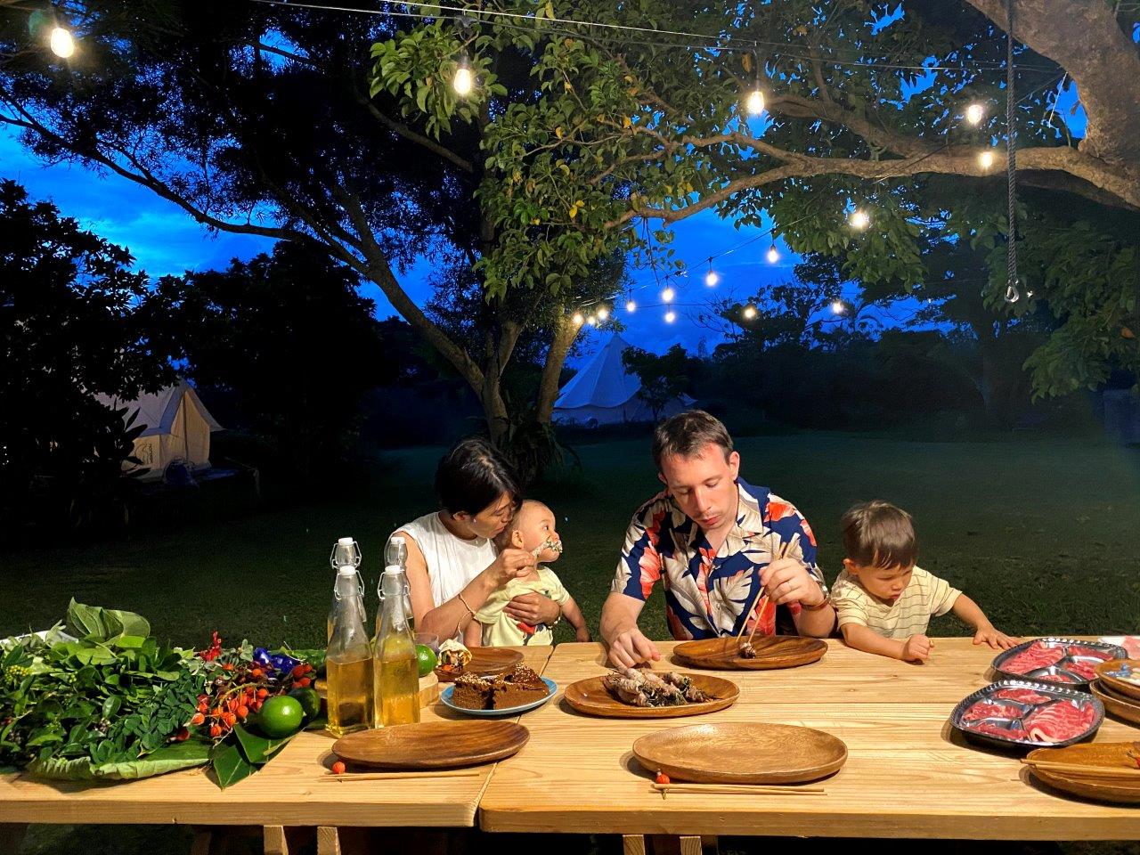 ライトアップされた庭で料理を食べるタサン志麻さんファミリー