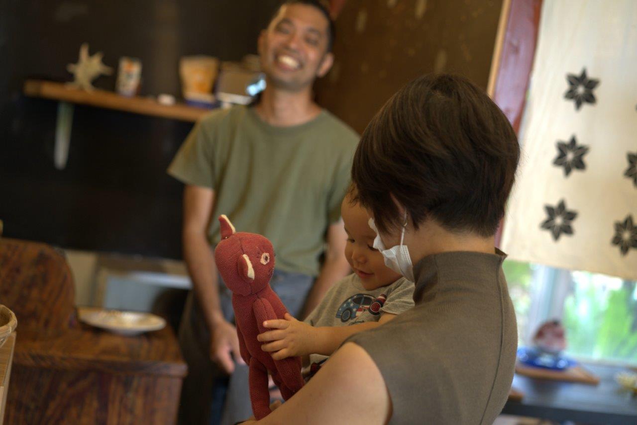 ネコ人形の笑顔で見るタサン志麻さんの息子さん