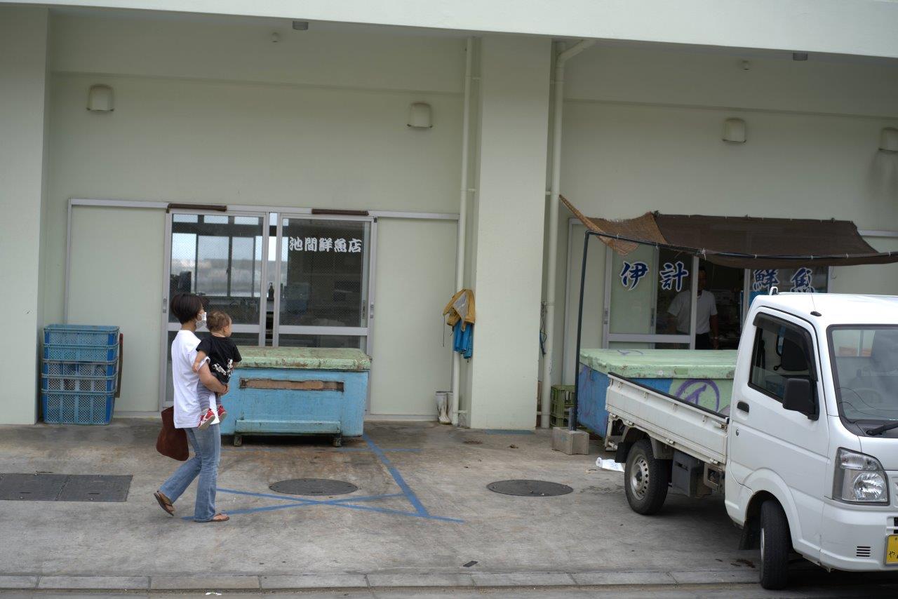 鮮魚店の入り口に向かうタサン志麻さん