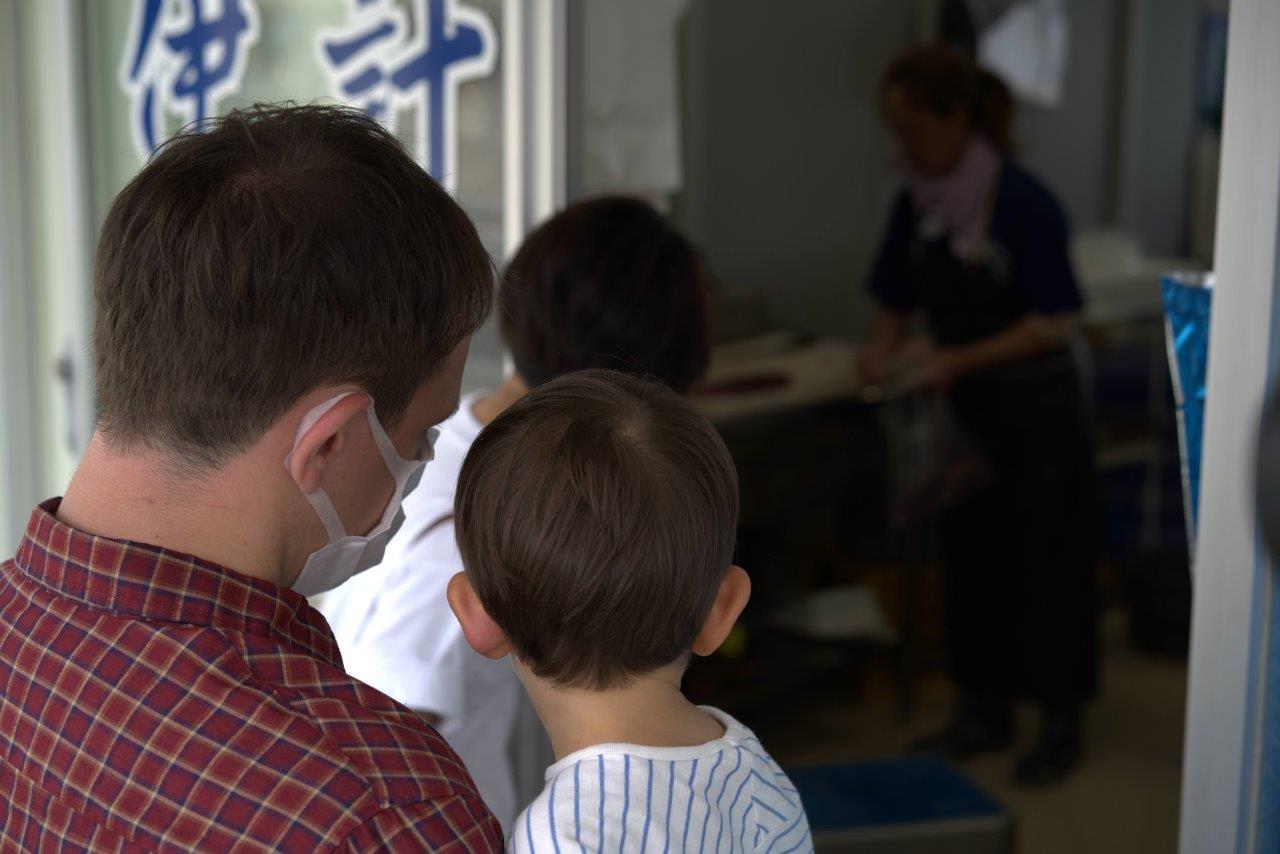 魚をさばく様子を見るタサン志麻さんファミリー