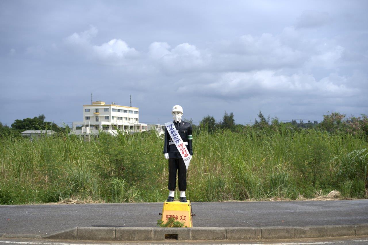 道脇に立つまもるくん