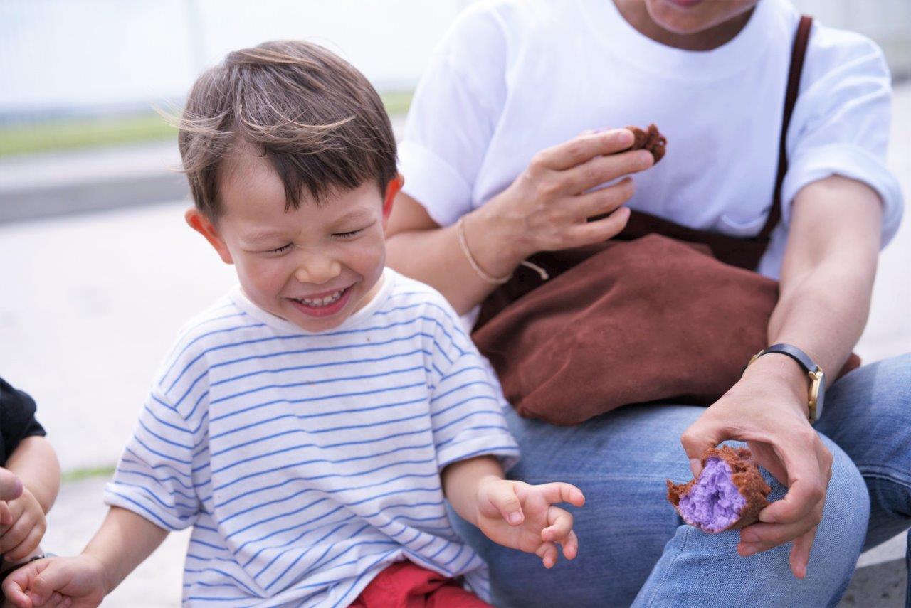 サーターアンダギーを食べておいしい笑顔